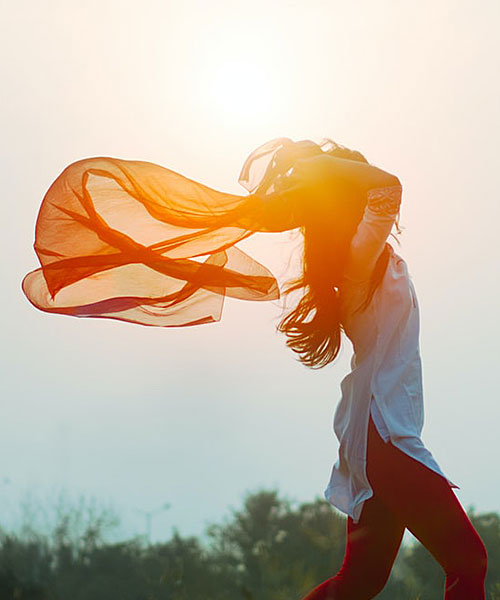 femme marchant vers l'avenir avec grand voile rouge qui inspire la liberté et la sérénité